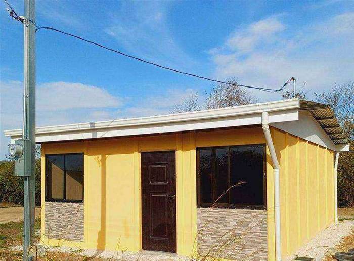 Casa amarilla de una planta con zócalo de piedra y canoas instaladas, entregada en San Ramón, Alajuela