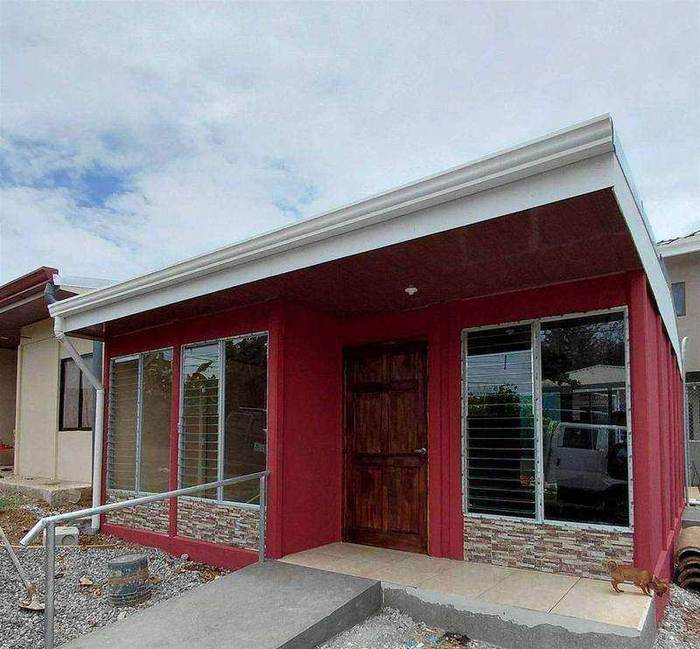 Casa roja de una planta con corredor techado y ventanas amplias, entregada en Desamparados, San José