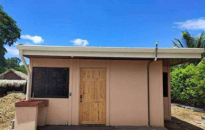 Casa color salmón de una planta con puerta de madera, entregada en Hatillo, San José